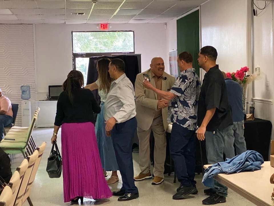 Group of professionals networking and shaking hands in a classroom or office setting