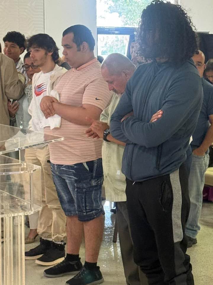 Group of men viewing a display case in an indoor gallery or museum setting